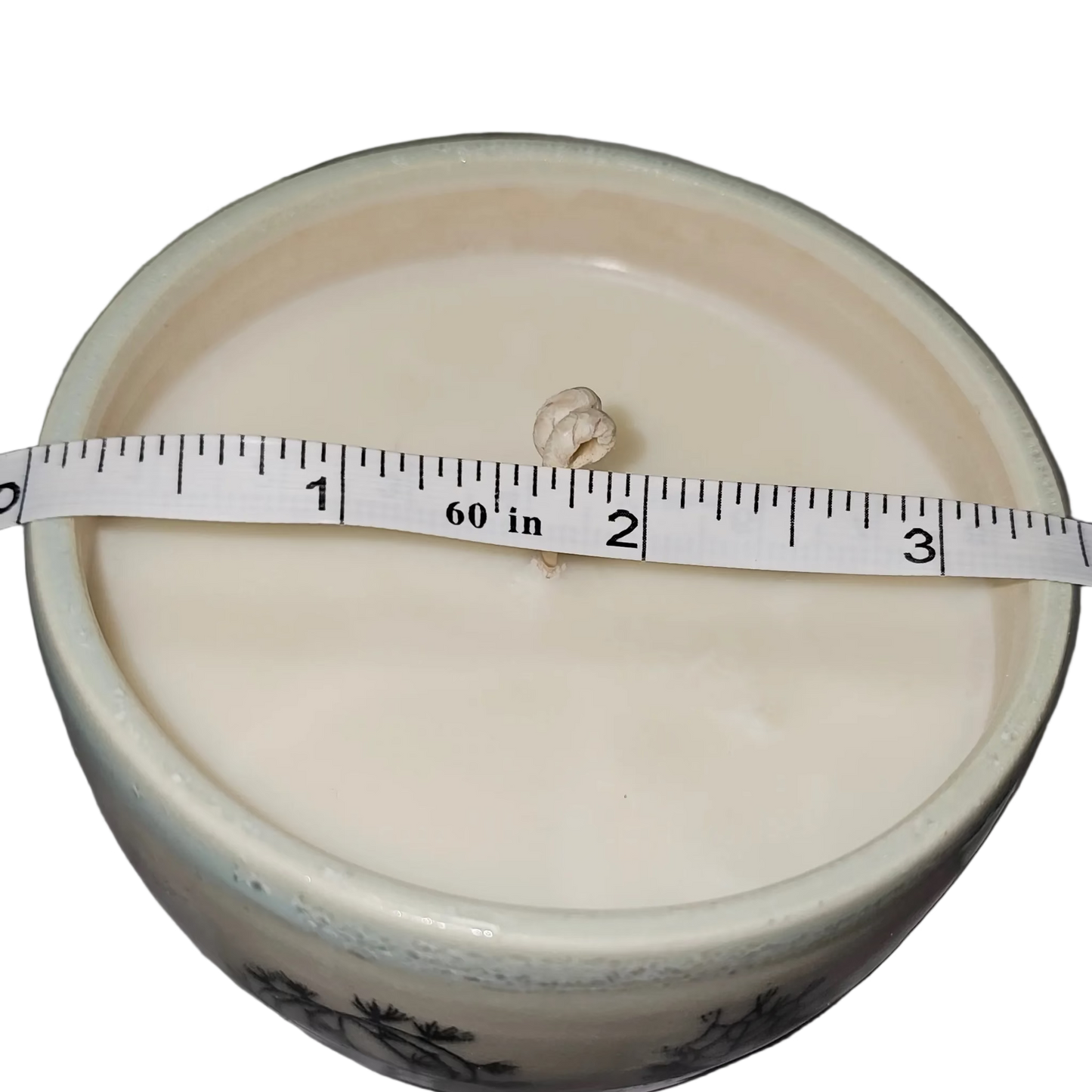 White container with a measuring tape on a gray surface, soy candle