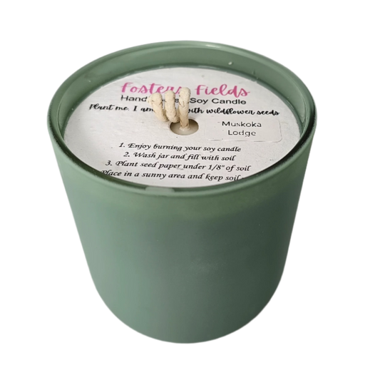 Candle in rich green vessel with warm, woodsy Muskoka Lodge fragrance