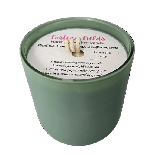 Candle in rich green vessel with warm, woodsy Muskoka Lodge fragrance