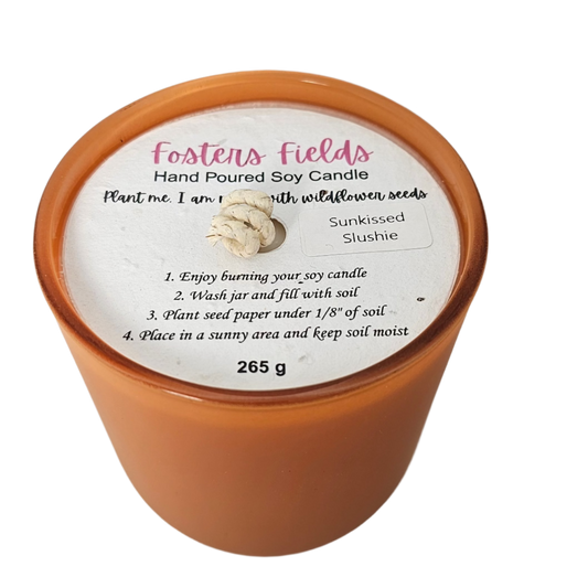 Artisan soy candle with citrus scent, hand-poured into an orange glass jar