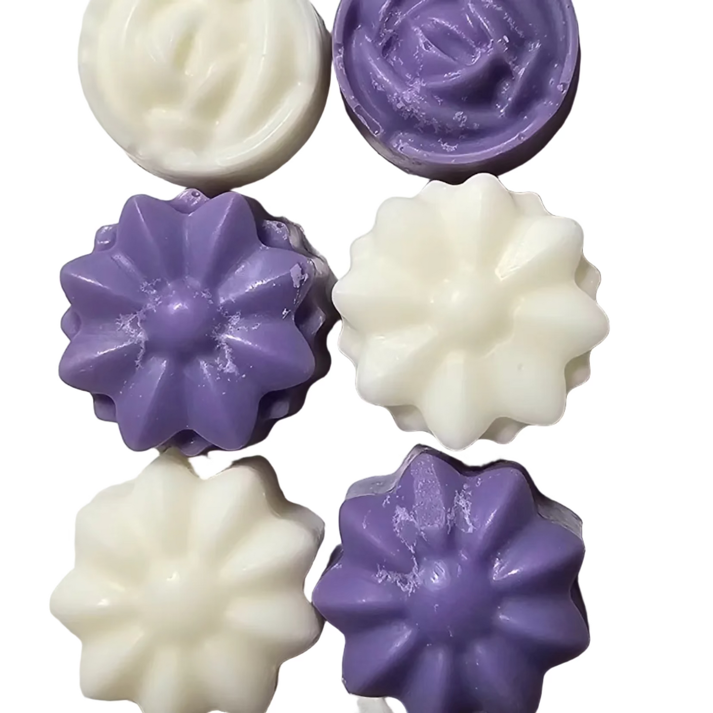six purple and white tiny flower shaped wax melts on a white background