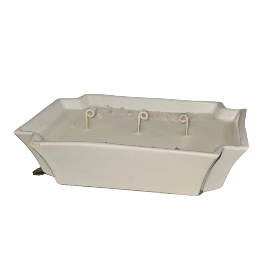 White rectangle bowl filled with soy wax, 3 wicks and rose quartz on top