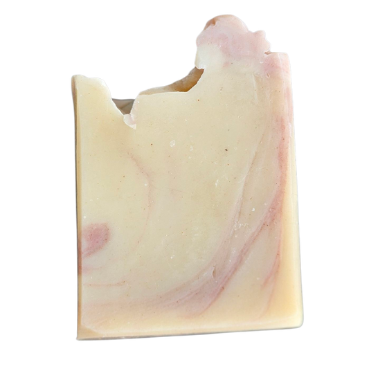 Uniquely shaped soap bar with pink and white swirls on a white background