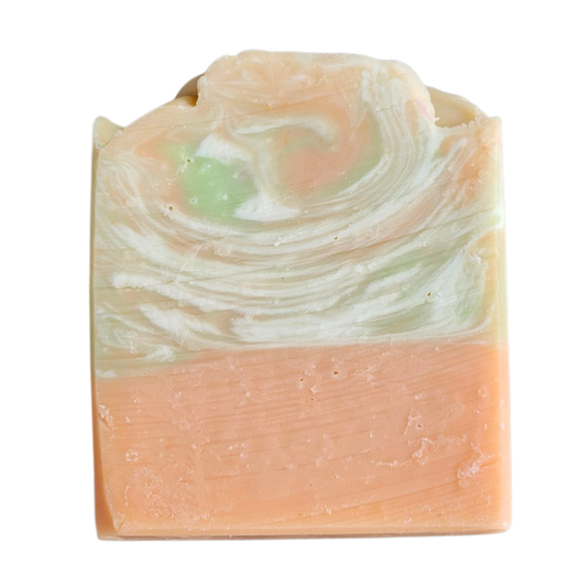 Swirled soap bar with peach and green colors on a white background