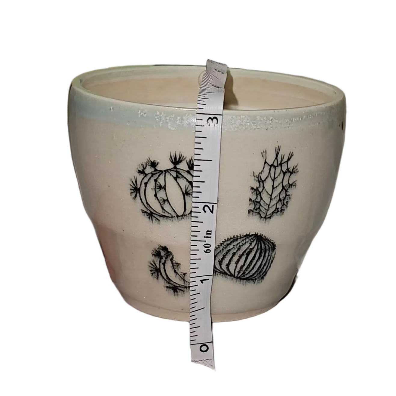 Ceramic mug with measurements being taken on a white surface with papers in the background