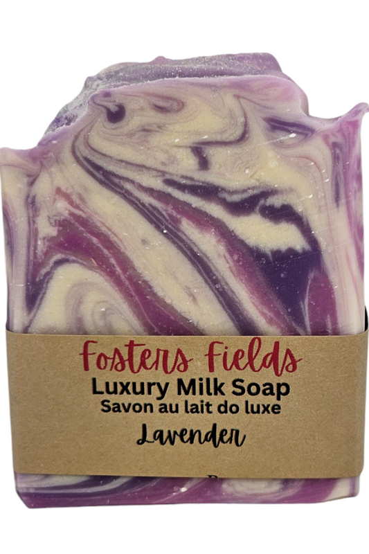 A bar of lavender essential oil soap made with coconut milk, featuring a beautiful swirl design in light and dark purple hues, interlaced with white. The colors blend seamlessly, creating a soothing and elegant pattern reminiscent of a peaceful lavender field