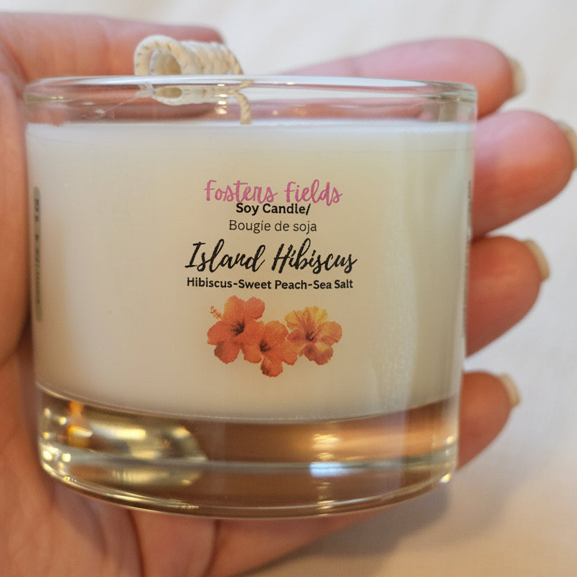 Hand holding a candle labeled 'Island Hisbiscus by Fosters Fields.