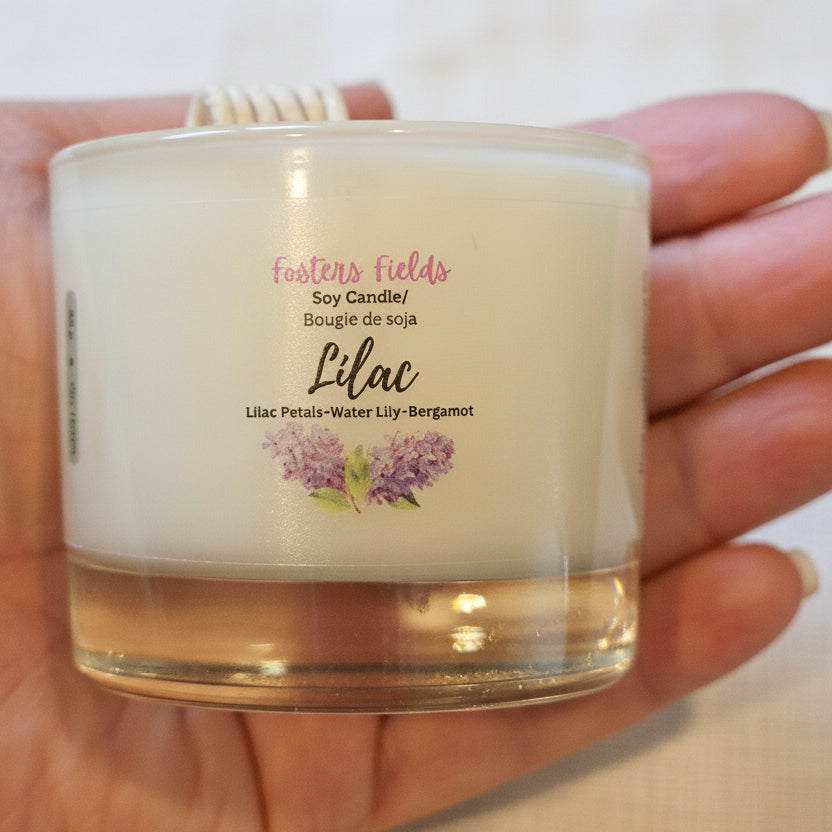 Jar of lip balm held in a hand with a blurred background