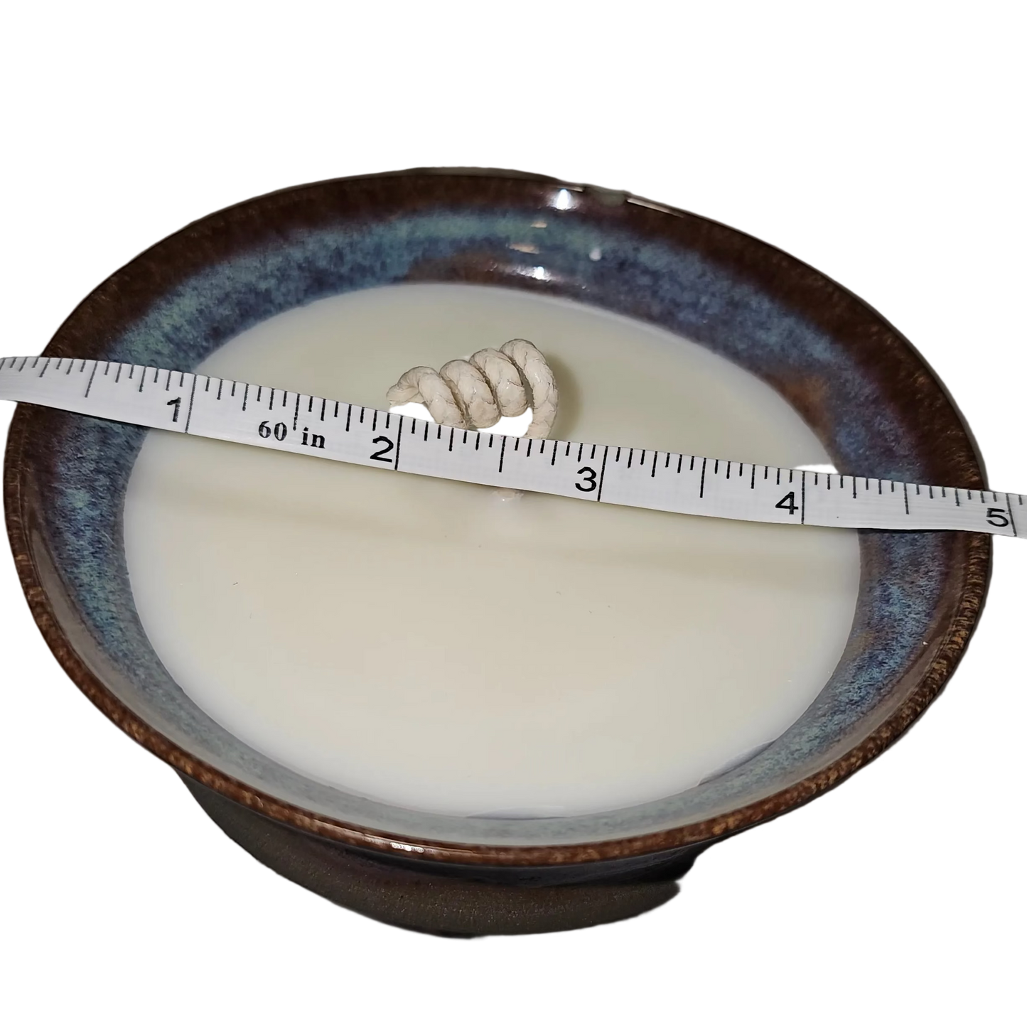 Bowl with a white substance and a measuring tape, on a gray surface. Soy Candle