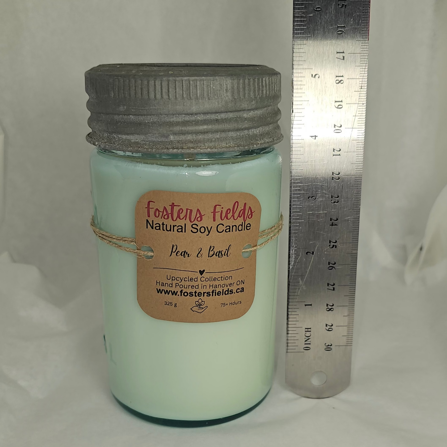 Candle jar with a label and a ruler on a white background