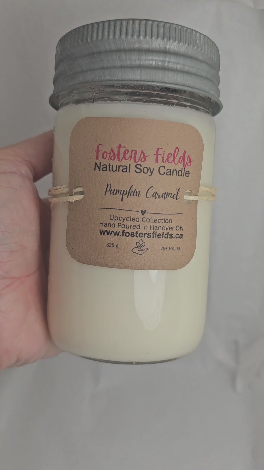 close up video of Pumpkin Caramel Soy Jar Candle, glass with glass and metls lid, some embossing on the upcycled jars nad lid