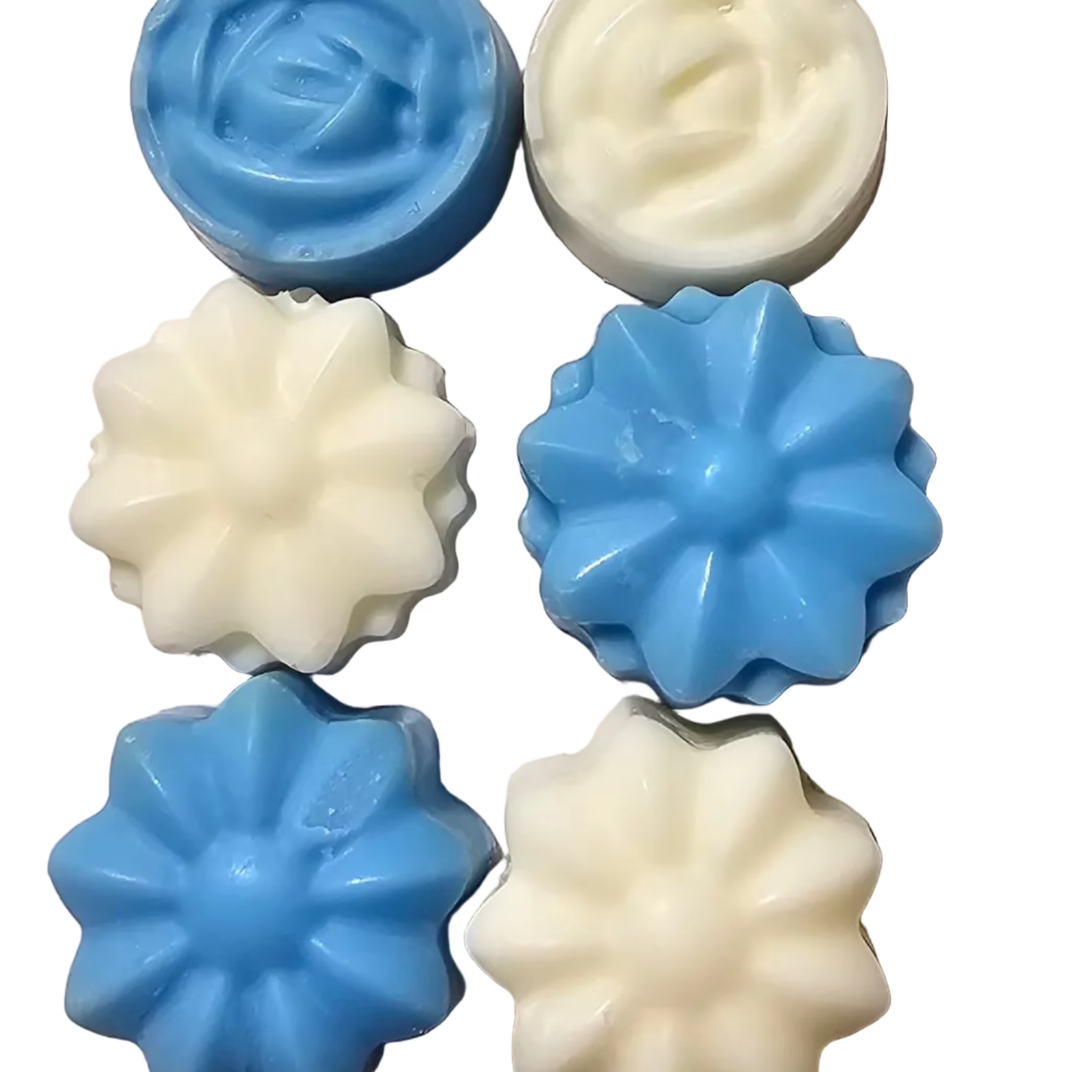 Five star-shaped soy wax flower shaped melts, three blue and three white, on a textured surface.